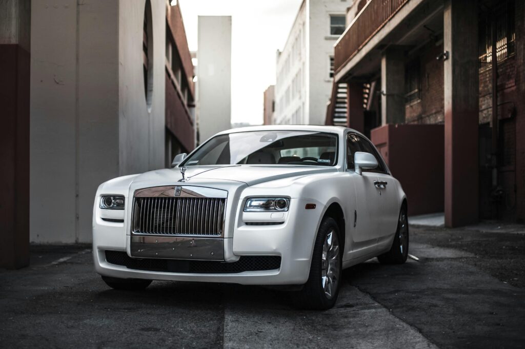 Elegant white luxury car parked in an urban alley, exuding sophistication and style.